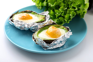 Baked avocado with eggs on white background