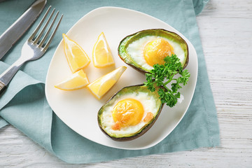 Baked avocado with eggs on table