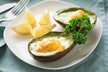 Baked avocado with eggs on table