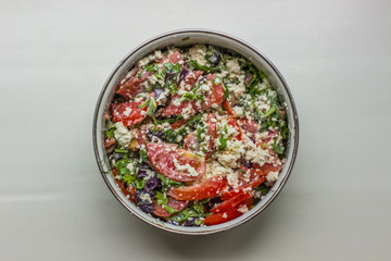 food concept of salad with cottage cheese tomatoes basil arugula and spice in bowl on white empty space for copy or text
