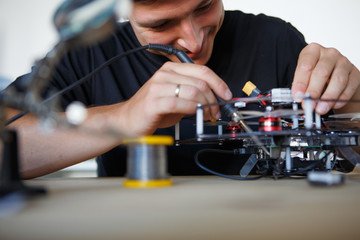 Image of man with soldering iron repairing mechanism