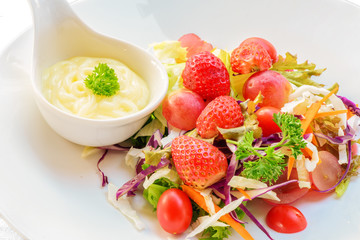 closeup of firuits salad and salad dressing in spoon