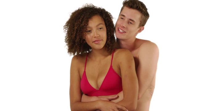 Happy interracial couple embracing at the beach on white background with copyspace, Portrait of happy Caucasian male hugging his girlfriend, looking out at the ocean in studio, 4k