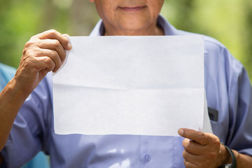the elder man hold a paper in hand