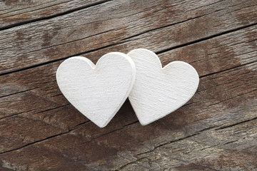 Fototapeta premium Two hearts on old wooden background