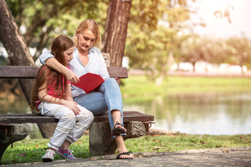 Fototapeta premium Family is reading happily together in the garden.Soft focus concept.