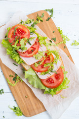baguette sandwich with ham, tomatoes and lettuc