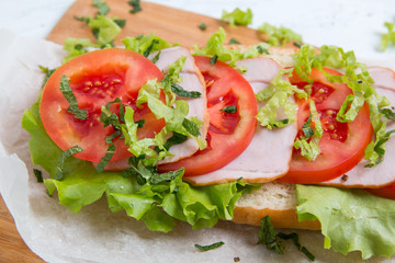 baguette sandwich with ham, tomatoes and lettuc