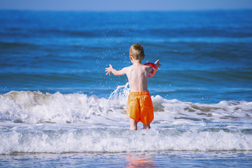 funny boy swimming in the sea in summer