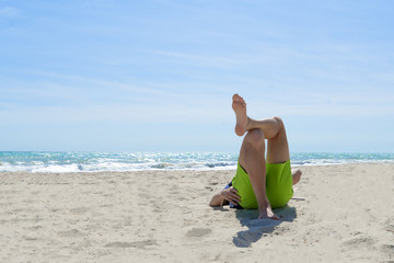 Lazy time. Man lies leg to leg on sea beach on a summer day