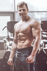 Obraz premium handsome strong bodybuilder athletic men pumping up muscles with dumbbells