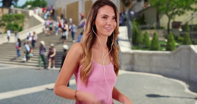 Woman listens to music with smartphone in Rome, Happy smiling female relaxing with music in the summer, 4k