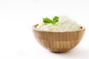 Fresh cottage cheese in a wooden bowl isolated on white background. Copyspace