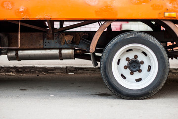 Naklejka premium Old truck's rear wheel and old rusty parts hiden under new painted body
