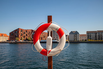 Obraz premium Close up view of floating ring with city river and buildings on background in Copenhagen, Denmark