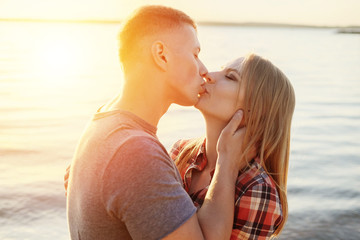 couple happy on the beach sunset romantic kiss close-up