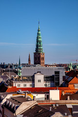 aerial view of old tower with tall spire and cityscape in copenhagen, denmark