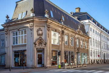Fototapeta na wymiar beautiful historical building with large windows and decorative sculptures on street in copenhagen, denmark