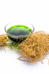 Close up of dark green colored herbal syrup of Khus or vetiver grass isolated on white in a...