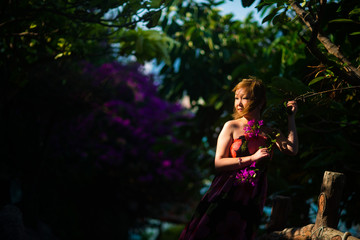 Portrait of a beautiful adult Asian woman in the jungle at sunset