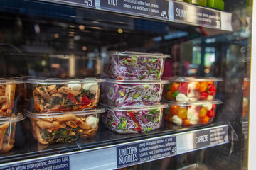 front view of various types of salad in plastic containers
