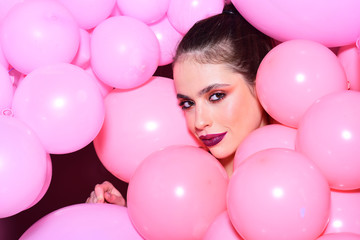 Fototapeta na wymiar Fashion woman with many pink air balloons. Birthday decor and celebration. girl dreaming in punchy pastels trend. Retro girl with stylish makeup and hair. Balloon party on pink studio background