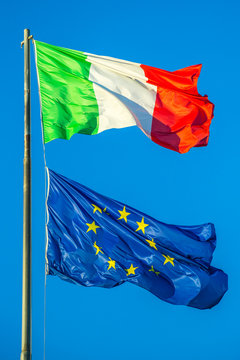 Flags of Italy and Europe waving in the blue sky background. Concept for financial treated, unique currency and financial bond