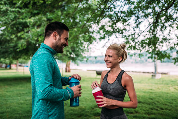 Fit couple drinking water after workout.