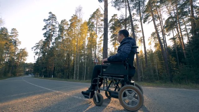 Disabled person in a powered wheelchair starts moving