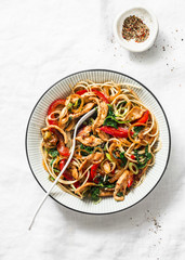 Teriyaki chicken, bell peppers, onions, spinach and rice noodles stir fry on white background, top view. Asian style healthy food