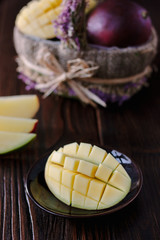 Fresh and juicy mango, cut by halves over wooden table.