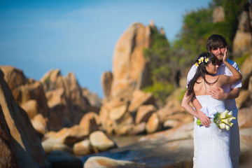 the bride and groom hugging gently on the beautiful coast