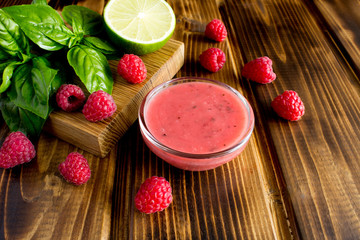Salad sauce  with  raspberries and basil on the brown wooden background