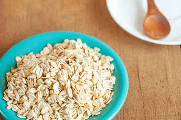 Oats flakes in dish on wood table
