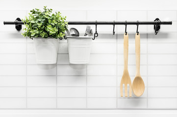 Cooking symbol in home kitchen background, White kitchen with hanging flower with stainless steel cutlery and wooden tools detail - 208954350