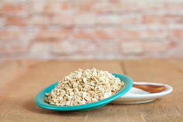 Oats flakes in dish on wood table