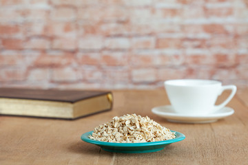 Oats flakes in dish on wood table