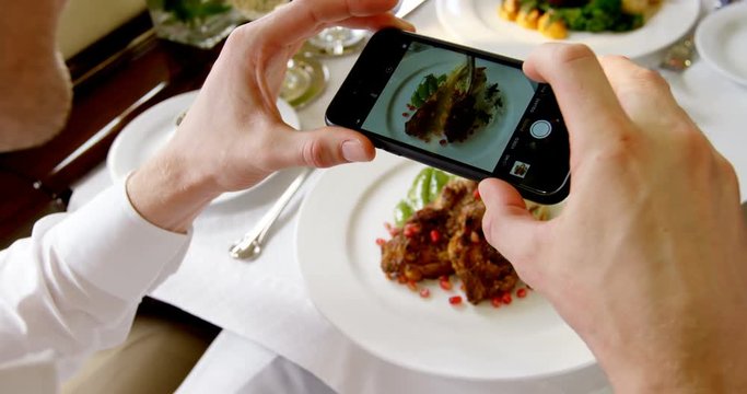 Businessman taking photo of meal with mobile phone 4k