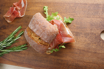 sandwich with prosciutto jamon on a wooden background