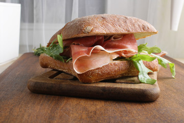 sandwich with prosciutto jamon on a wooden background