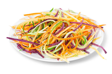 mix red, yellow, orange carrots, zucchini and cucumber julienned vegetables for salad on plate, concept of healthy food