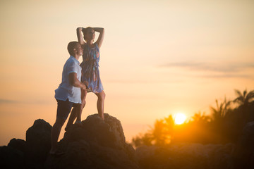 Young couple enjoying sunset in the rocks