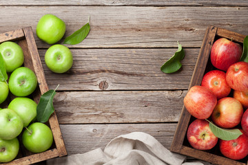 Green and red apples in wooden box