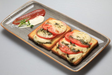 Two tomato and cheese sandwiches