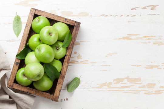 Green apples in wooden box
