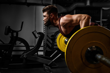 Young athlete lifts barbell to his chest. Concept workout