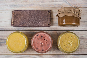 Honey in a glass jar on a light wooden background with a chalkboard