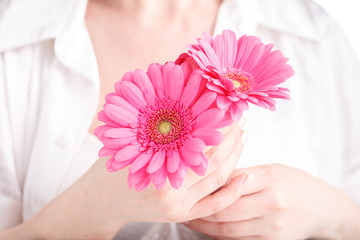 Obraz na płótnie Canvas Woman hygiene conception. Pink flower gerbera in female hands