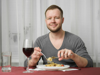 Man eating pasta and smiling