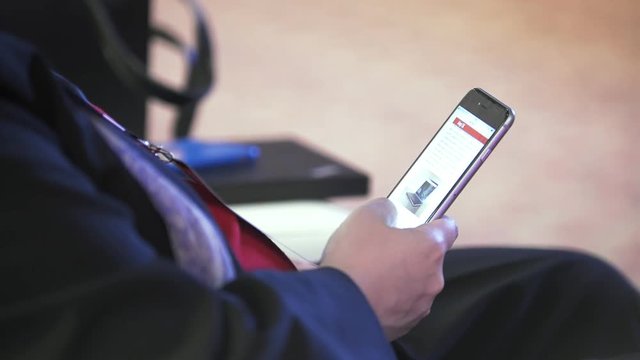 Man uses the smartphone during sitting at the business conference